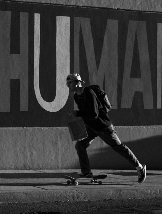 a man riding a skateboard down a sidewalk