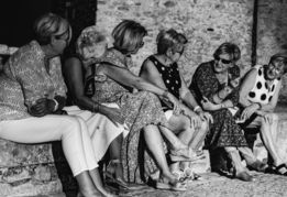 a group of women sitting on a bench with a panda bear