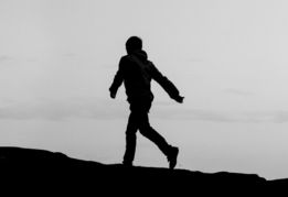a person standing on top of a hill near the ocean